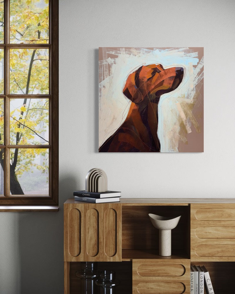A square painting depicting an abstract portrait of a brown dog, displayed on a light gray wall above a wooden console cabinet in a styled room setting.