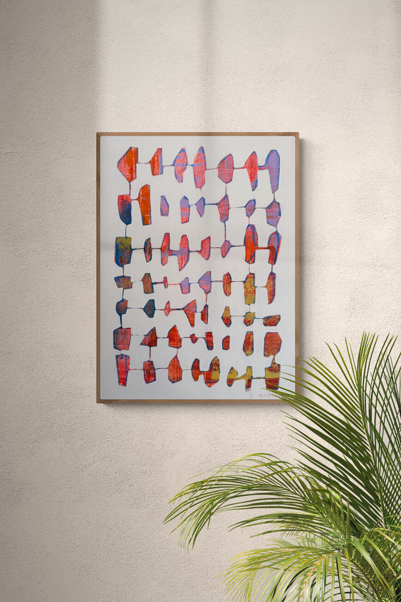 Colorful abstract art piece on a wall with a plant in the foreground.