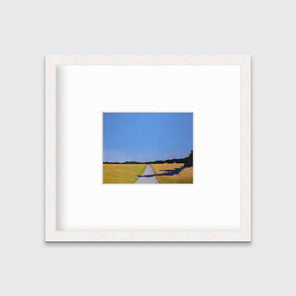 A blue and yellow-green abstract landscape print on paper, framed in a white wood frame hangs on a light wall. 
