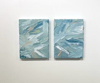 A video of a pair of thickly painted paintings in teal, sea foam green, celadon, white and hints of orange and yellow by Teodora Guererra.