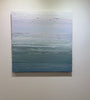 A video of a teal blue, teal green, lavender and pale lavender textured abstract painting by Teodora Guererra hangs on a white wall.