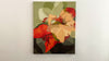 A video of an Abstract floral painting with red, orange, and beige flowers on a light gray background hanging on a white wall.