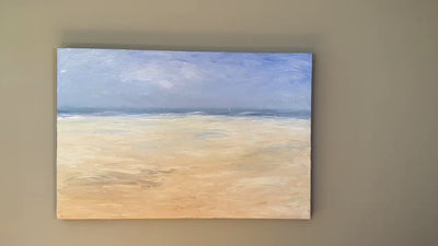 An abstracted coastal seascape painting hangs on a grey wall. 
