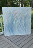 Video of an original Abstract painting with texture in blue, green, white, and pink leaning on a deck.