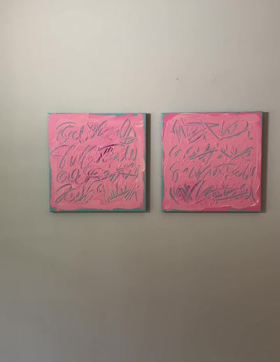 A video of two square pink text based paintings with writing into the surface with various tools, carving fluid script that reveals the teal color hidden below. Displayed side-by-side on a white wall.