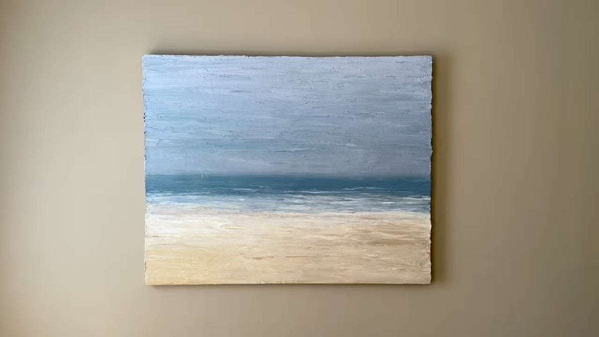 A video of an abstracted coastal seascape painting hangs on a grey wall.