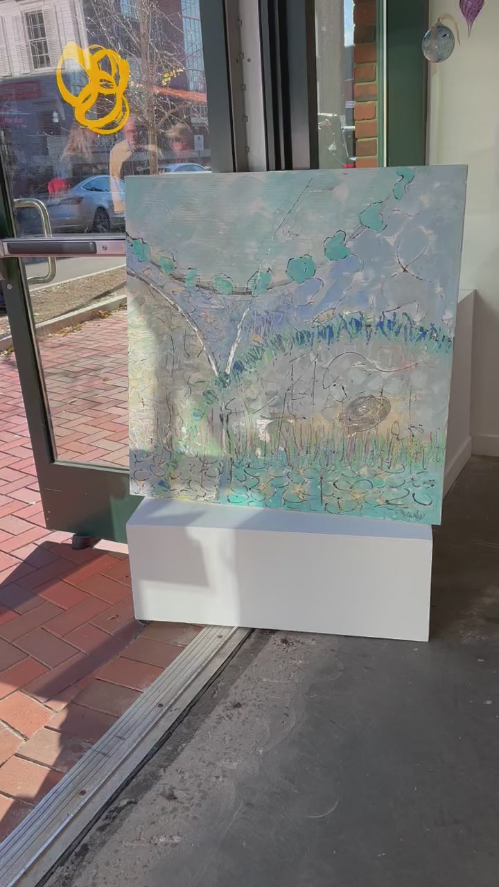 A video of a blue and turquoise abstract painting hangs on a white wall. 