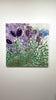 A video of a  green, blue, and violet abstracted floral painting hangs on a white wall.