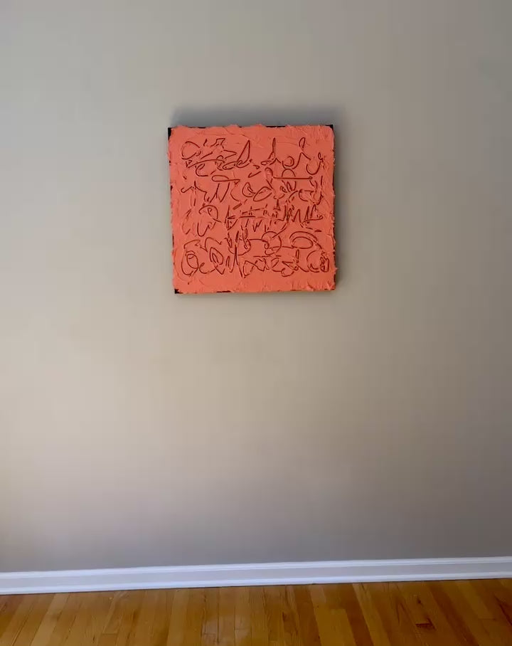 A video of a square abstract painting with a textured coral-pink surface and dark calligraphic line work, mounted against a light gray wall.