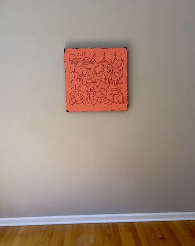A video of a square abstract painting with a textured coral-pink surface and dark calligraphic line work, mounted against a light gray wall.