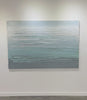 A video of a white, teal and grey heavily textured abstract painting like sculpture by Teodora Guererra hangs on a white wall.
