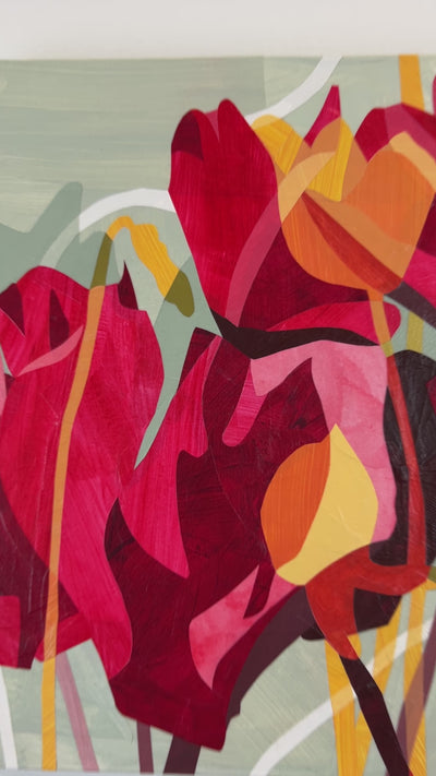 A video of a colorful abstract floral artwork on a wall, featuring predominantly red and pink tones with touches of yellow and green hanging on a white wall.