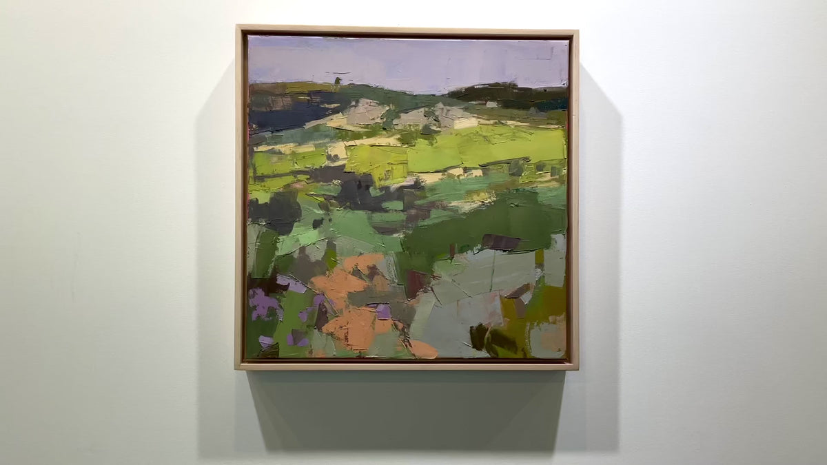 A textured abstract landscape painting hangs on a white wall.