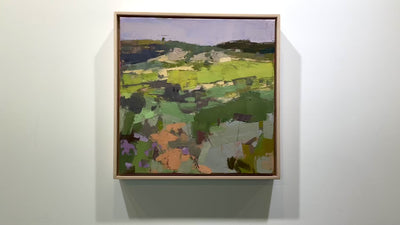 A textured abstract landscape painting hangs on a white wall.