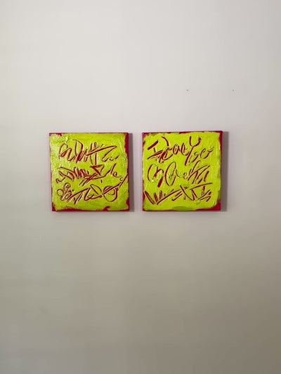 A video of two square abstract text-based paintings with textured chartreuse over hot raspberry pink  graffiti-style lettering, displayed side-by-side on a white wall.