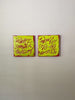 A video of two square abstract text-based paintings with textured chartreuse over hot raspberry pink  graffiti-style lettering, displayed side-by-side on a white wall.