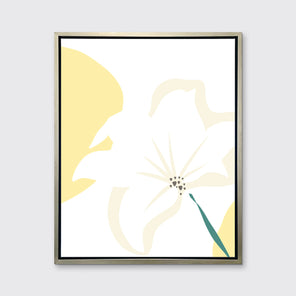 A light yellow abstract botanical art print framed in a silver floater frame hangs on a light wall.