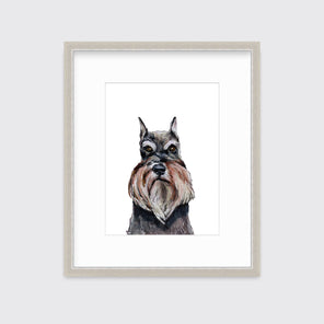 An illustration of a Schnauzer dog framed in a silver frame hangs on a white wall.