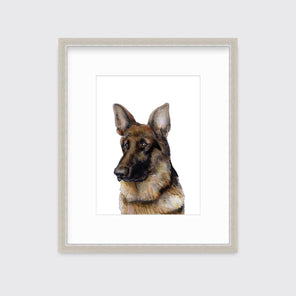 An illustration of a German Shepherd dog framed in a silver frame hangs on a white wall.
