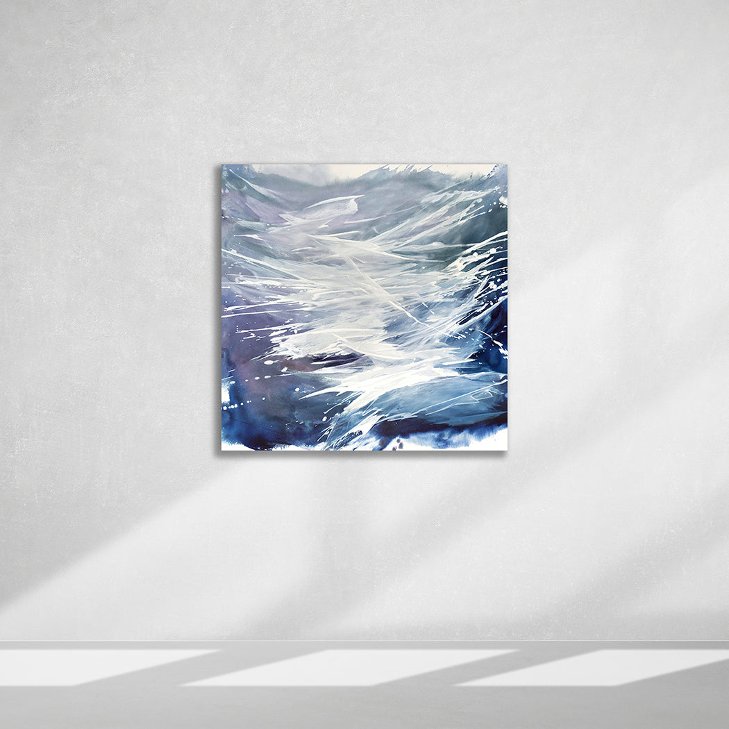 An original artwork featuring abstract blue and white colors with a dynamic wave form, signed by Teodora Guererra hangs on a white wall.