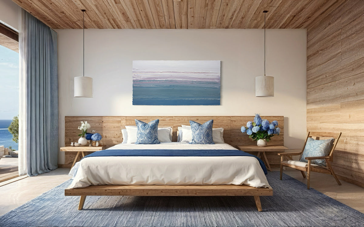 Modern bedroom with wooden platform king bed, blue accents, and ocean view. An original abstract painting hangs over the bed.