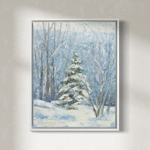 A blue, white and green snow fall landscape painting with one snow covered pine tree in the center by Molly Doe Wensberg hangs in a white floater frame on a white wall.