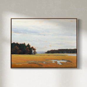 A light blue, dark green and shades of orange abstract landscape painting by Molly Doe Wensberg hangs in a light wood floater frame on a white wall.