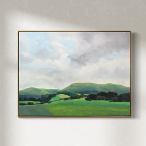 A light grey and shades of green landscape painting by Molly Doe Wensberg hangs in a light wood floater frame on a white wall.