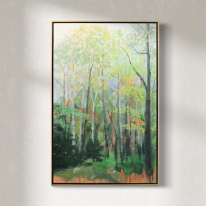 A green and orange framed painting of a forest hangs on a white wall. 