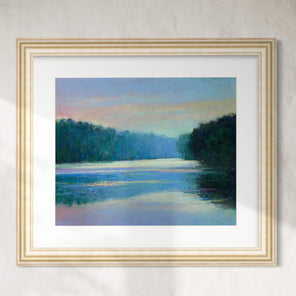 Framed painting of a landscape with a river and trees on a white wall