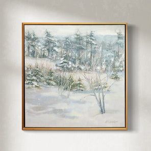 A white, grey and green snow landscape painting by Molly Doe Wensberg hangs in a light wood floater frame on a white wall.