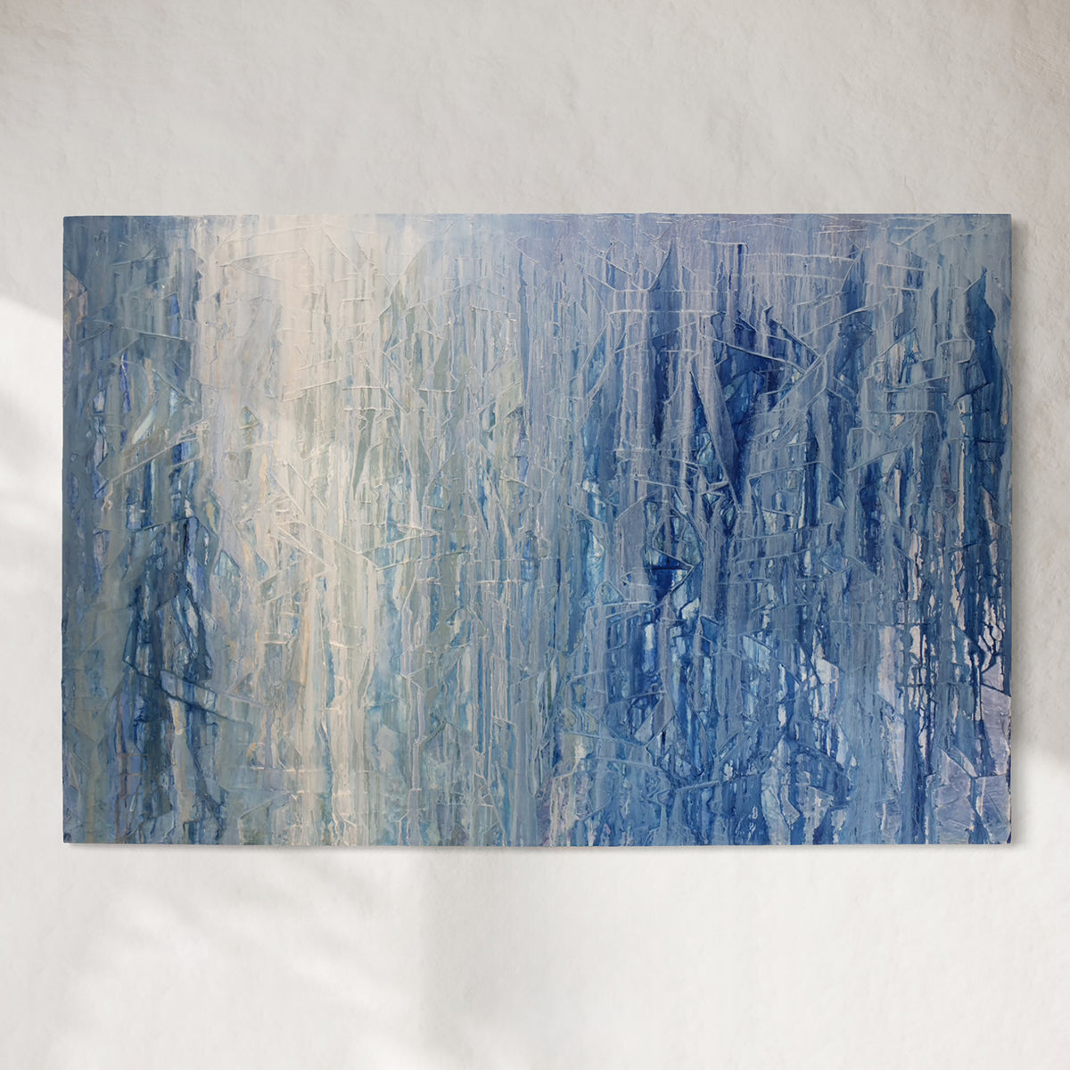 Abstract painting with blue and gray tones on a white wall