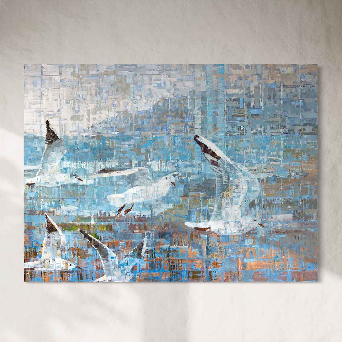 Abstract painting of seagulls over water with a textured background hanging on a white sun filled wall.