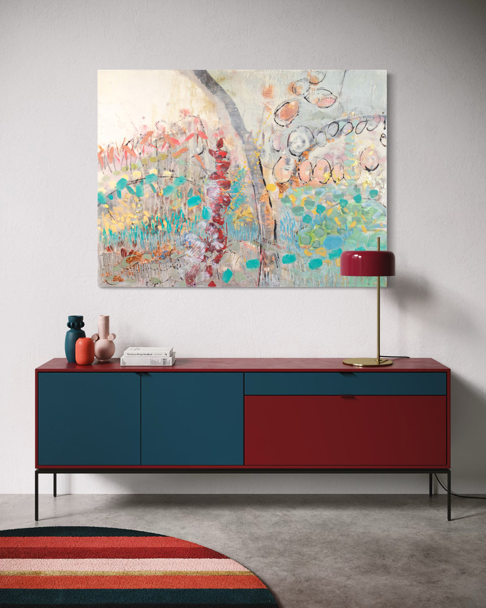 Modern interior with a colorful sideboard, abstract painting, and decorative items.
