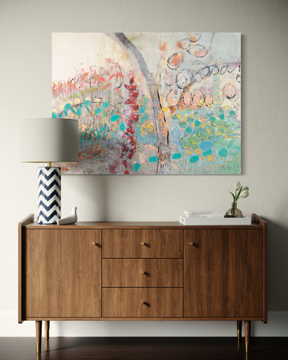Wooden sideboard with a colorful abstract painting above it on a gray wall.