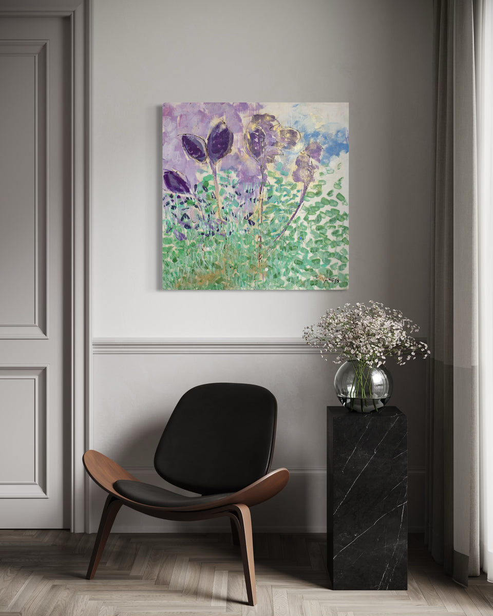 Modern interior with a black chair, black side table, and floral arrangement against a gray wall with a colorful abstract painting.