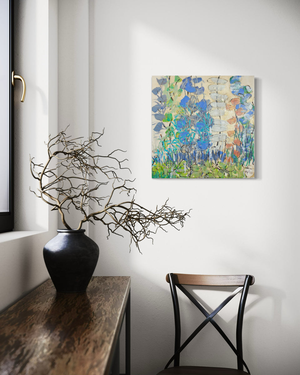 Decorative setup with a vase, branches, and a colorful abstract painting on a wall.