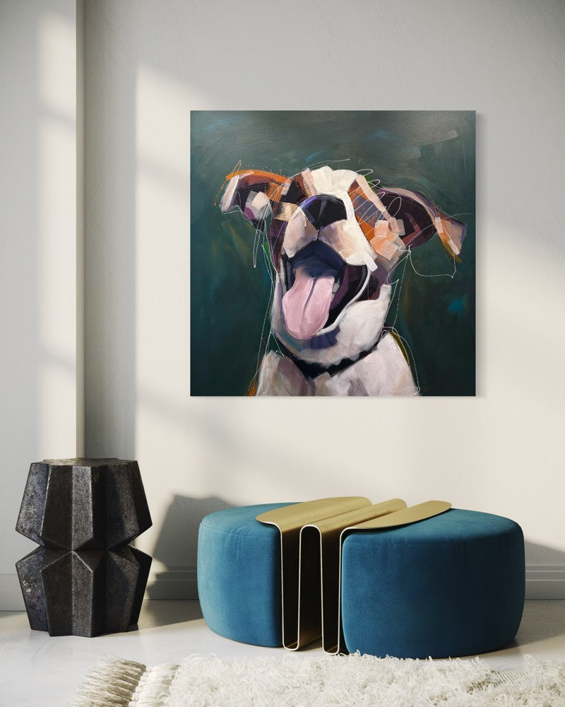 A square painting depicting an expressive dog portrait in warm earth tones, displayed on a light gray wall in a modern room setting above a blue velvet ottoman.