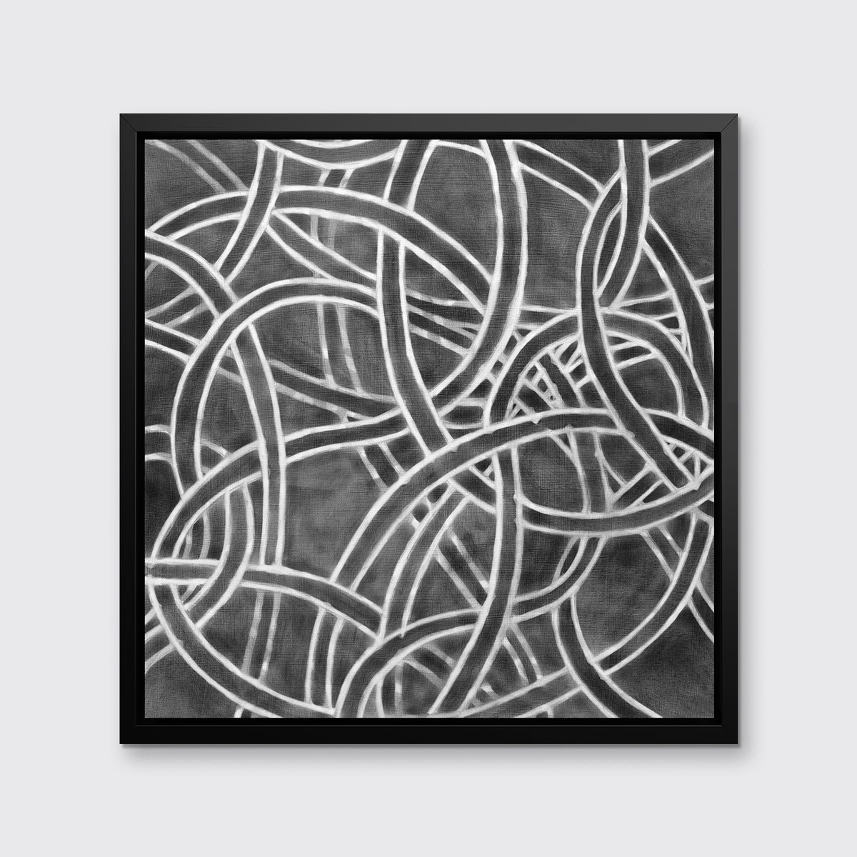 A dark grey and white abstract print in a black floater frame hangs on a white wall.