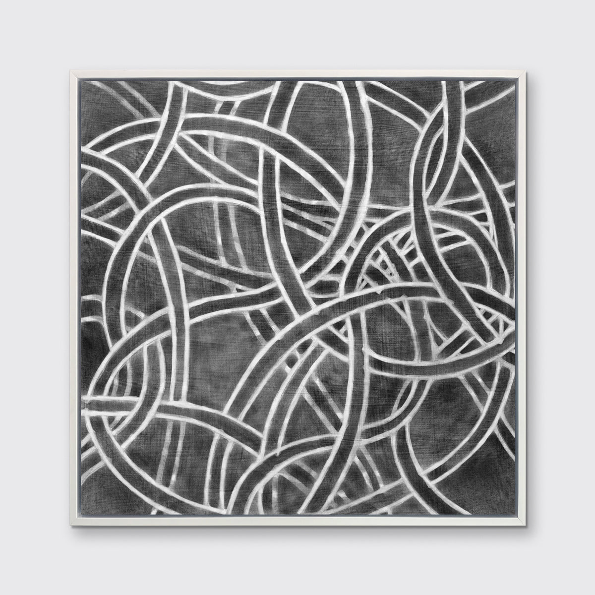 A dark grey and white abstract print in a white floater frame hangs on a white wall.