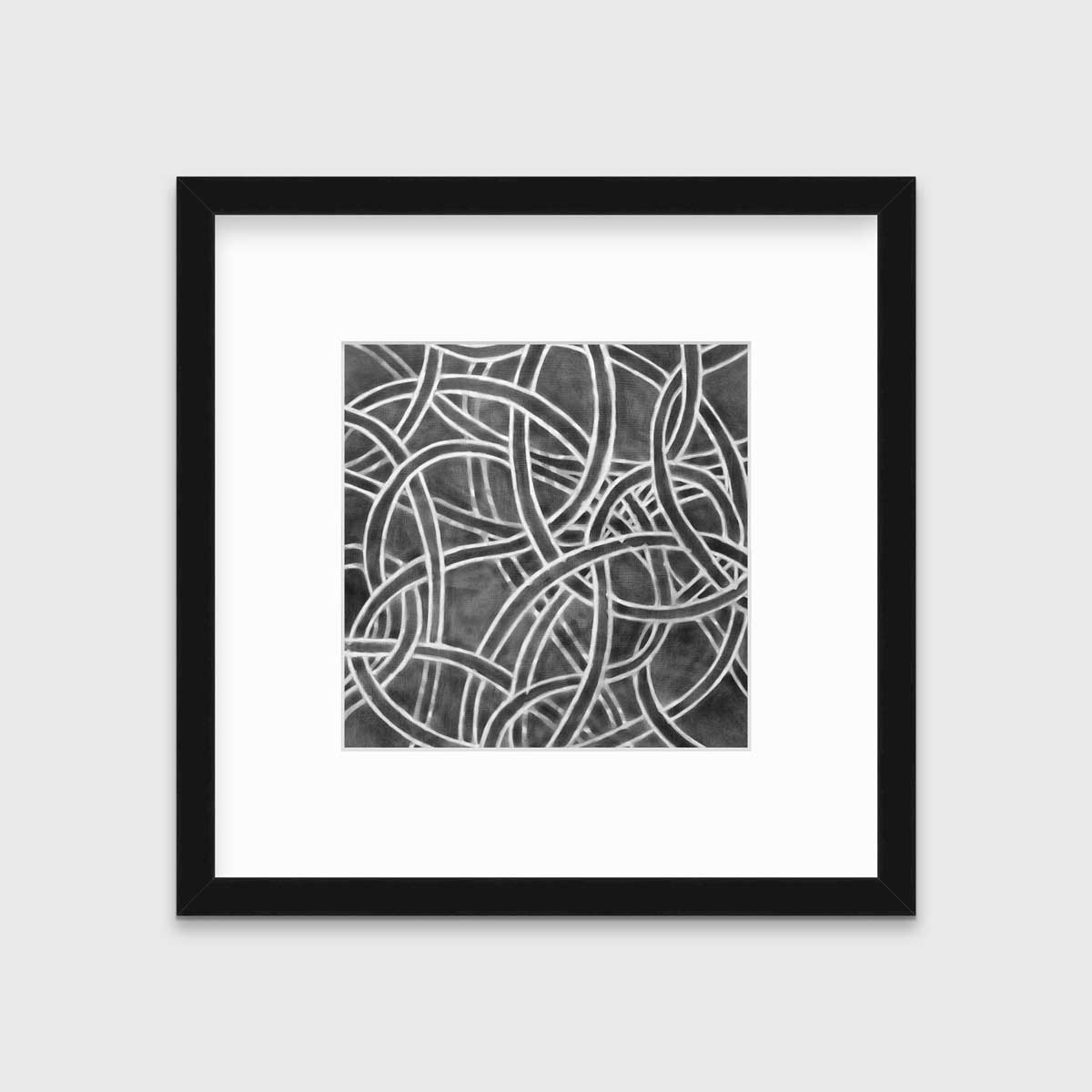 A dark grey and white abstract print in a black frame with a mat hangs on a white wall.