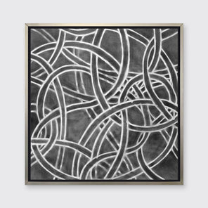 A dark grey and white abstract print in a silver floater frame hangs on a white wall.