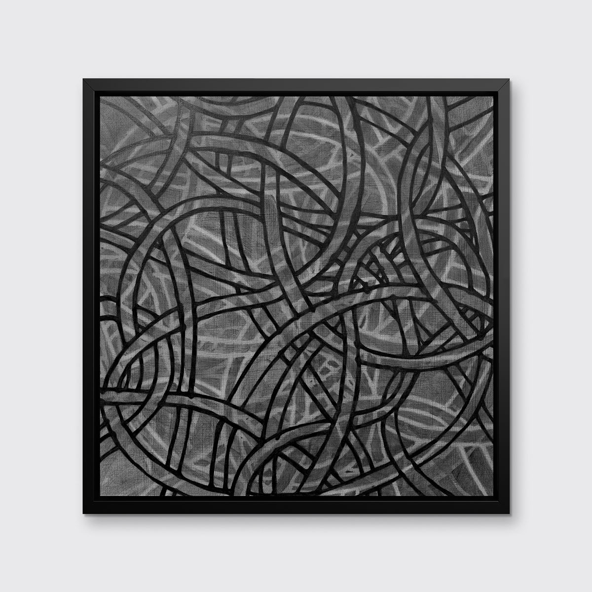 A black, grey and white abstract print in a black floater frame hangs on a white wall.