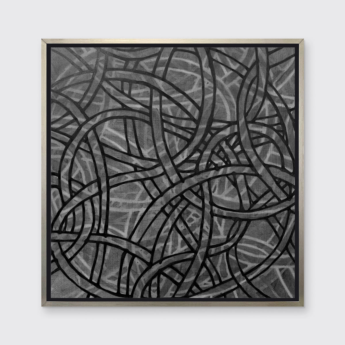A black, grey and white abstract print in a silver floater frame hangs on a white wall.