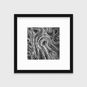 A dark grey and white abstract print in a black frame with a mat hangs on a white wall.