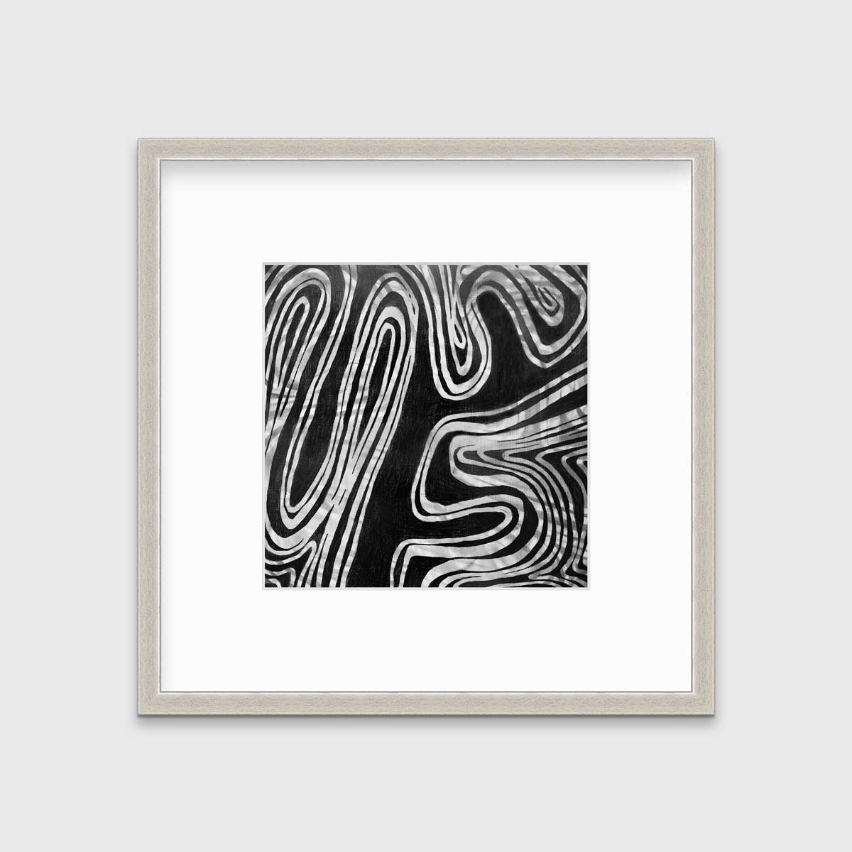 A black and white abstract print in a silver frame with a mat hangs on a white wall.