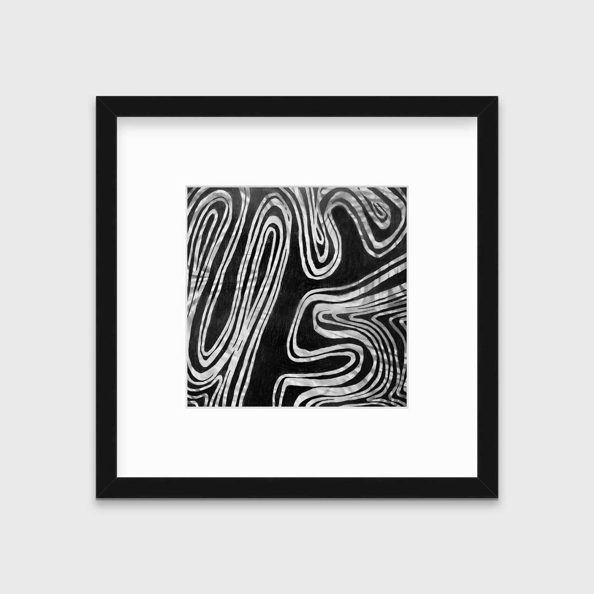 A black and white abstract print in a black frame with a mat hangs on a white wall.