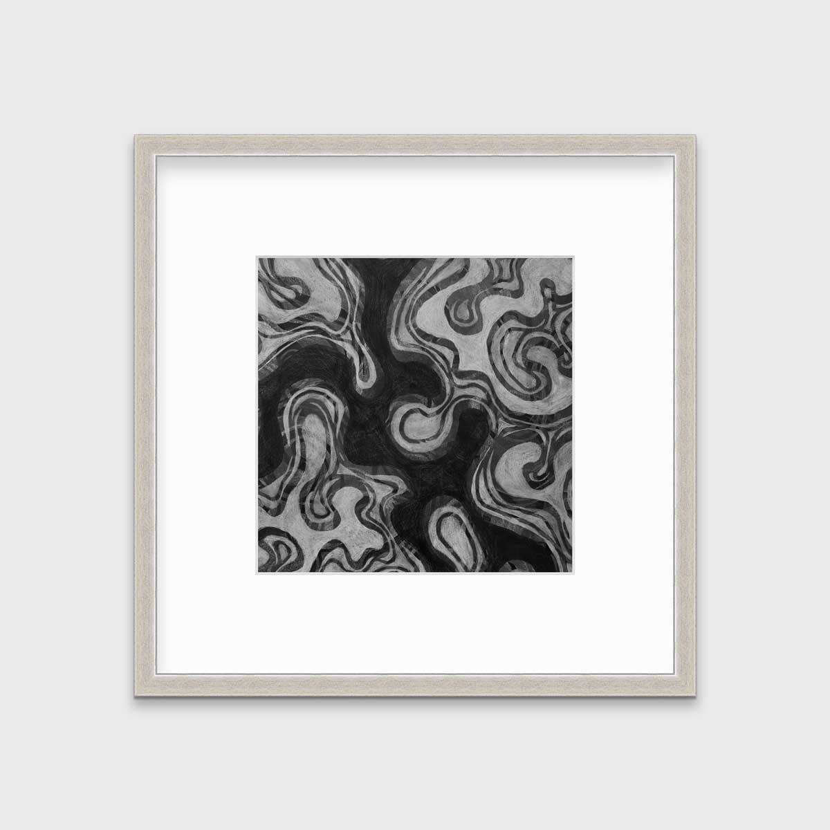 A black and grey abstract print in a silver frame with a mat hangs on a white wall.