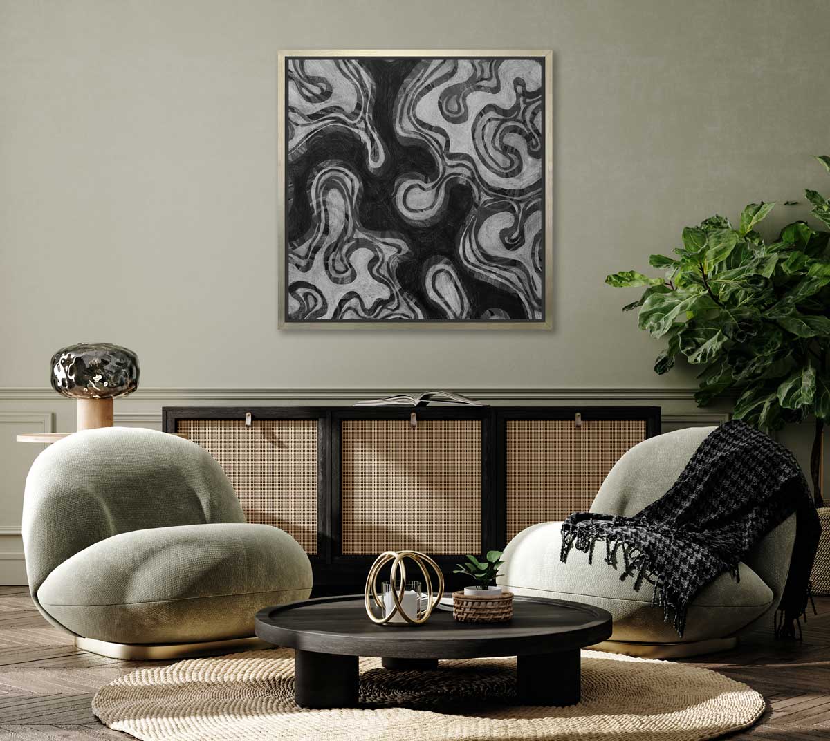 A black and grey abstract print in a silver floater frame hangs on a light green wall above a black and rattan sideboard, two modern light green chairs and a low black round coffee table.