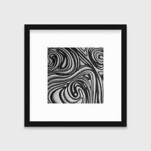 A black and grey abstract print in a black frame with a mat hangs on a white wall.